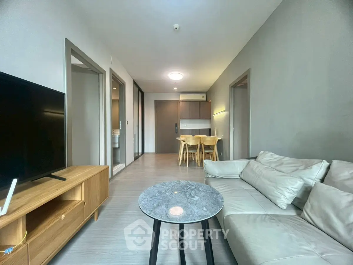 Modern living room with sleek furniture and open dining area