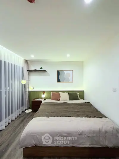 Modern bedroom with cozy decor and ambient lighting, featuring a large bed and stylish artwork.