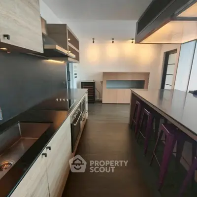 Modern kitchen with sleek design and open layout featuring high-end appliances and stylish lighting.