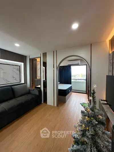 Modern living room with elegant decor and cozy ambiance, featuring a stylish sofa and a glimpse of the bedroom.
