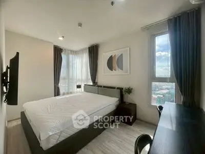 Modern bedroom with large windows and stylish decor in a high-rise apartment.