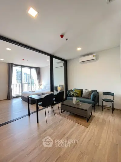Modern open-plan living room with stylish furniture and city view, perfect for urban living.