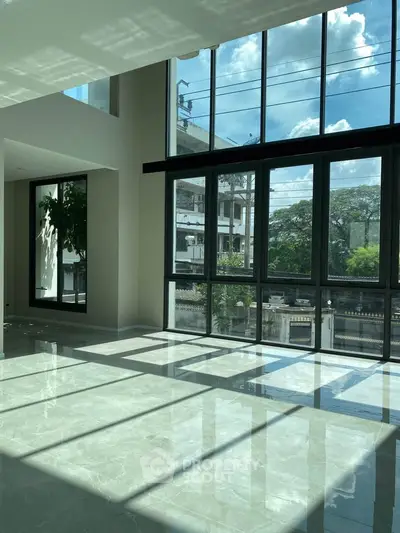 Spacious modern living room with floor-to-ceiling windows and stunning natural light.