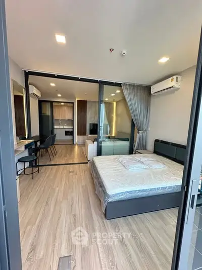 Modern studio apartment with open layout, featuring a cozy bedroom and stylish kitchen area.