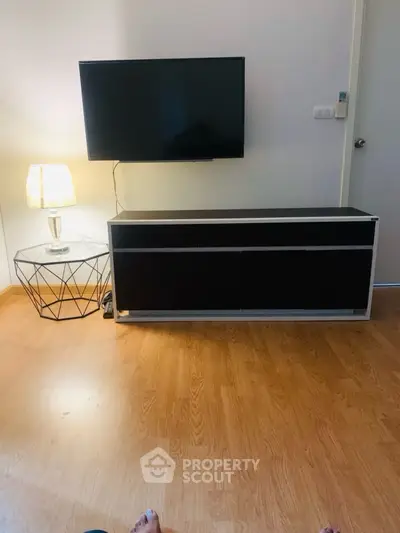 Modern living room with TV and stylish lamp on wooden floor