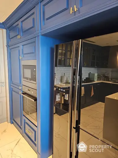 Modern kitchen with blue cabinetry and built-in appliances