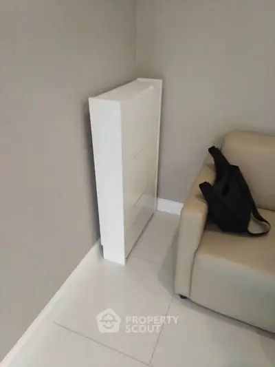 Modern living room with sleek white storage cabinet and beige sofa, perfect for minimalist design enthusiasts.