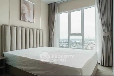 Spacious bedroom with large window offering stunning cityscape views, elegant decor, and natural light.