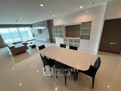 Spacious modern living room with dining area and large windows offering natural light.