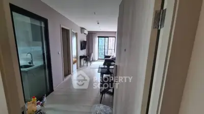 Modern apartment interior with open layout and natural light, featuring a cozy living area and kitchen.