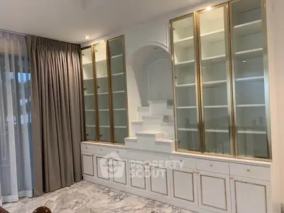 Luxurious living room with elegant built-in glass cabinets and marble flooring