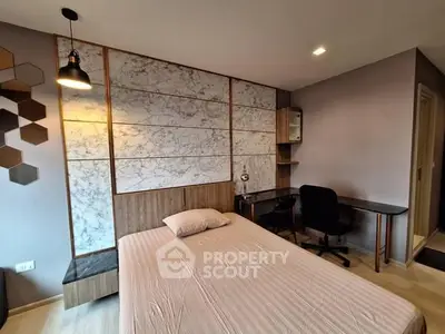 Modern bedroom with stylish decor and workspace, featuring a comfortable bed and sleek desk.