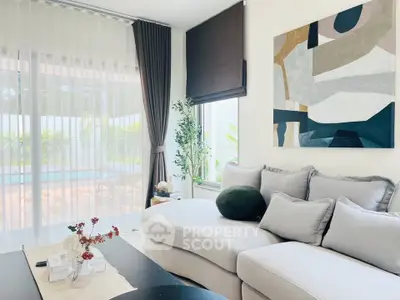 Elegant living room with modern decor and pool view, featuring a stylish sofa and abstract art.