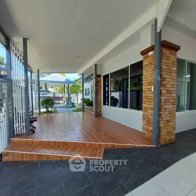 Spacious covered patio with modern design and brick accents, perfect for outdoor relaxation and entertainment.