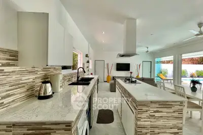 Modern open-layout kitchen with marble countertops and spacious living area