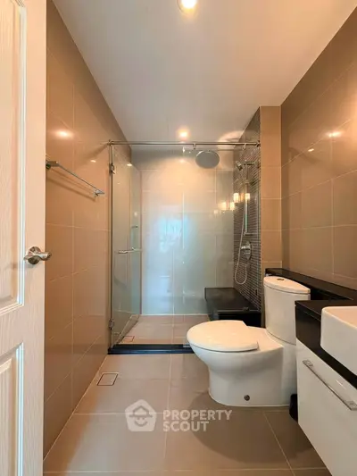 Modern bathroom with glass shower and sleek fixtures in a contemporary apartment.