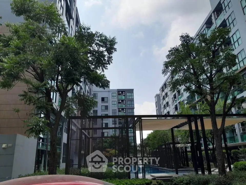 Modern apartment complex with lush greenery and outdoor pool area, perfect for urban living.