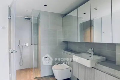 Modern bathroom with sleek design, featuring a glass shower and elegant fixtures.