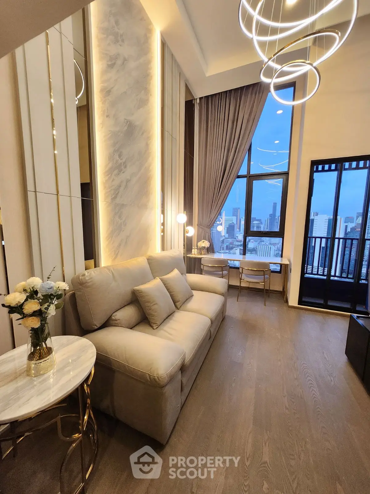Luxurious living room with modern decor and stunning city view from high-rise apartment.