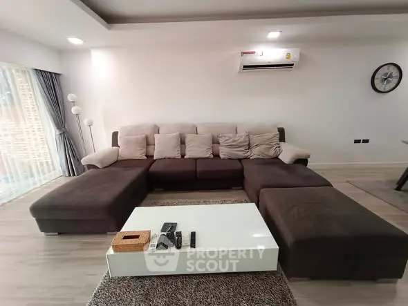 Spacious modern living room with large sectional sofa and sleek coffee table.