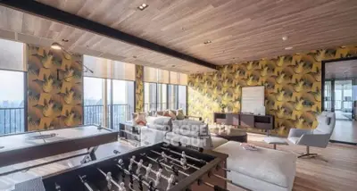 Luxurious living room with modern decor and stunning city view, featuring foosball and pool tables.