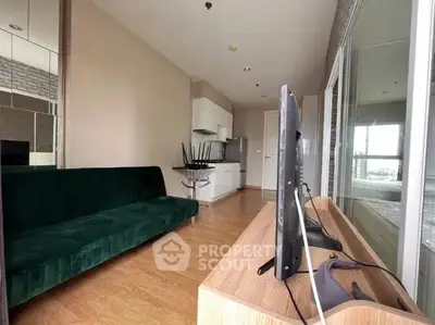 Modern living room with green sofa and open kitchen layout