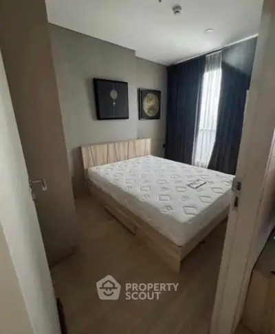 Cozy bedroom with modern decor and natural light, perfect for relaxation.