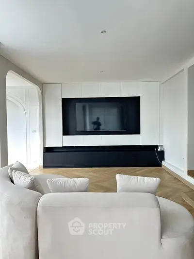 Modern living room with sleek TV setup and elegant white sofa