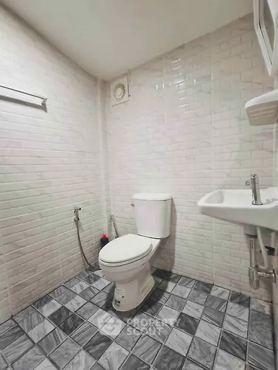 Modern bathroom with white brick tiles and checkered floor design