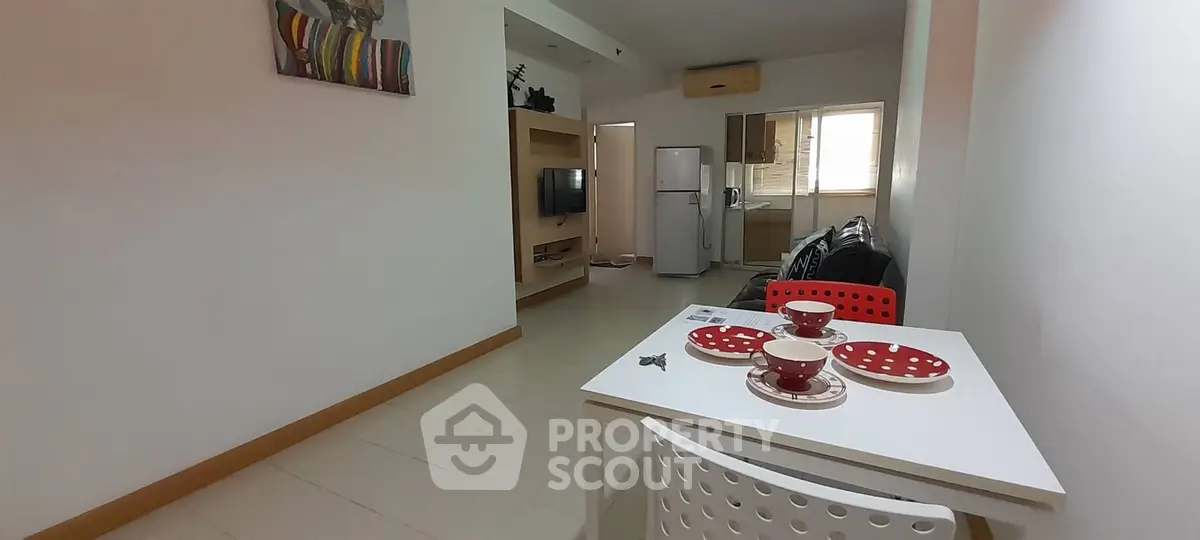 Modern open-plan living area with dining table and kitchen in a cozy apartment.