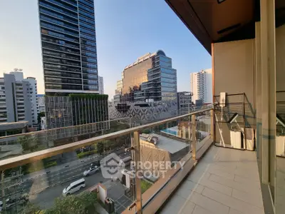 Stunning city view from a modern balcony with glass railing and urban skyline.