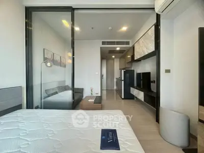 Modern studio apartment with sleek design and open layout, featuring a cozy bedroom and stylish kitchen.