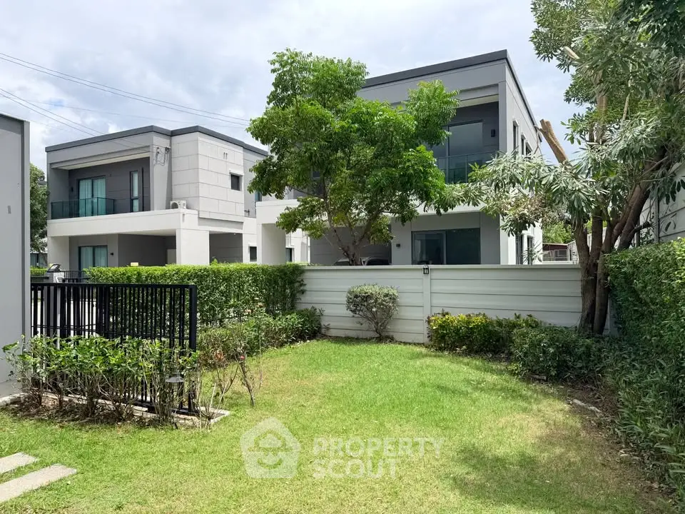 Modern residential building with lush garden and spacious balcony in a serene neighborhood.