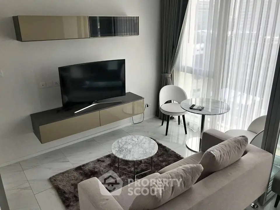 Modern living room with sleek furniture and large windows offering natural light.