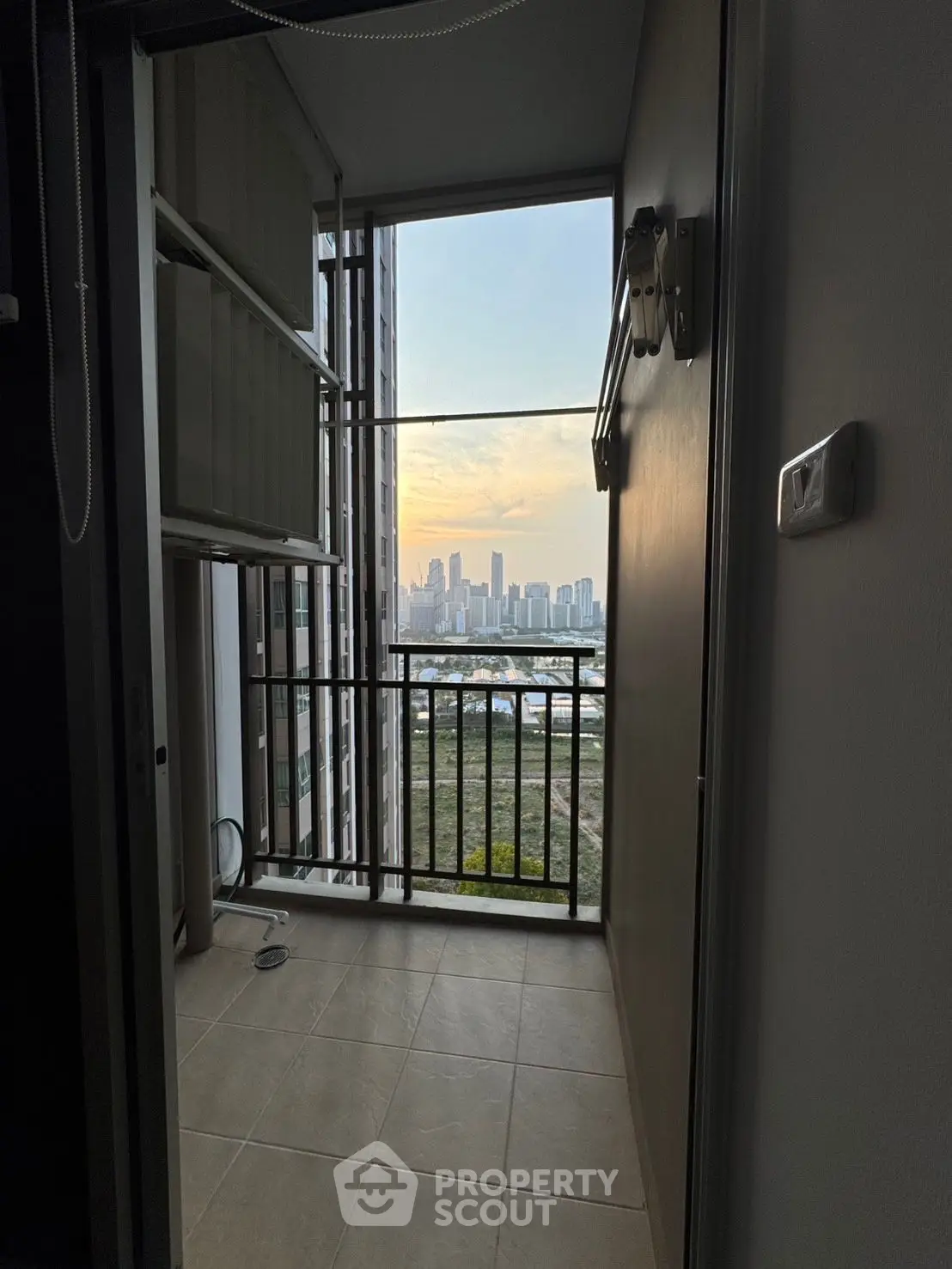 Modern balcony with stunning city view at sunset, perfect for urban living.
