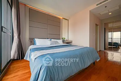 Modern bedroom with stylish decor and large windows offering natural light.