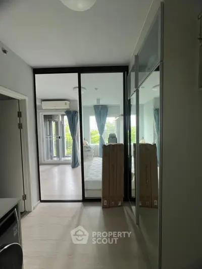 Modern bedroom with glass partition and balcony view in a stylish apartment.