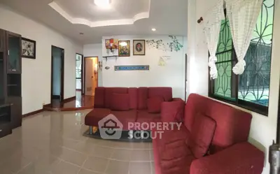 Spacious living room with red sofas and natural light