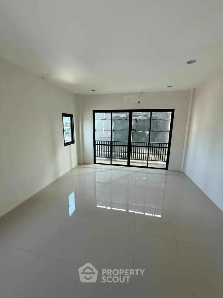 Spacious empty room with large windows and tiled flooring, perfect for customization.