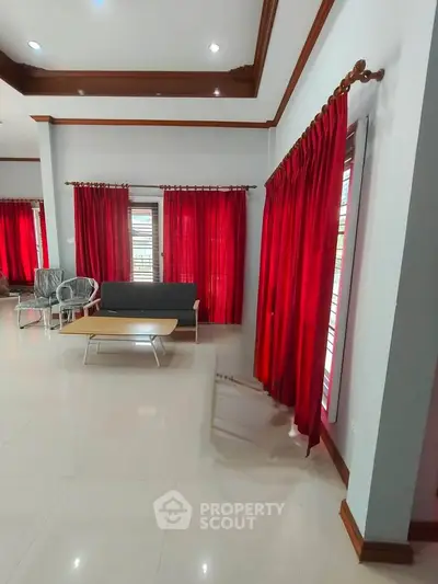Spacious living room with red curtains and modern furniture, perfect for relaxation and entertaining.