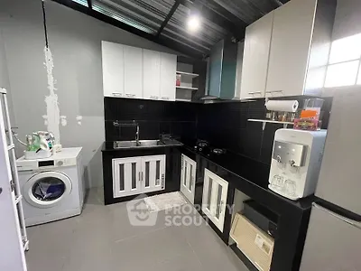 Modern kitchen with washing machine and sleek black countertops