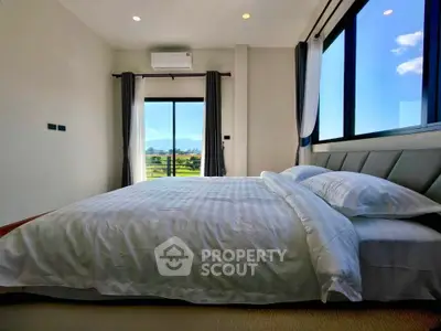 Spacious bedroom with large windows offering stunning views and natural light.