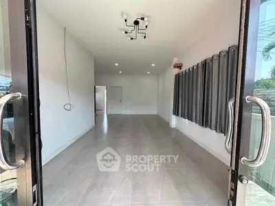 Spacious empty room with modern lighting and large windows, perfect for customization.