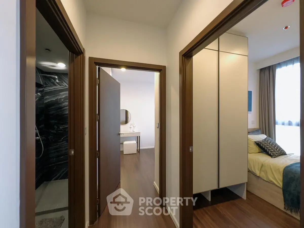 Modern apartment hallway with access to bedroom and bathroom, featuring sleek wood flooring and contemporary design.