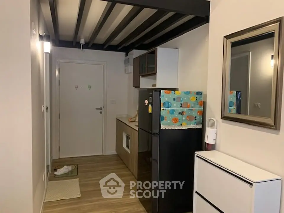 Compact apartment entryway with modern kitchenette and stylish decor