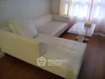 Stylish modern living room with white sectional sofa and elegant coffee table.