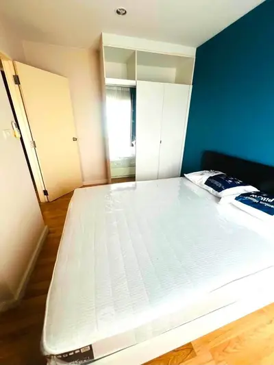 Bright bedroom with modern wardrobe and comfortable bed in stylish apartment.