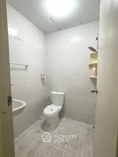 Compact bathroom with modern fixtures and tiled walls