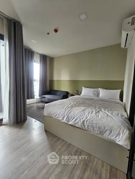 Spacious bedroom with modern decor and large windows for natural light.