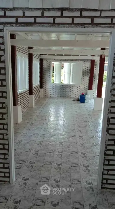 Spacious interior with brick walls and tiled flooring, perfect for customization.